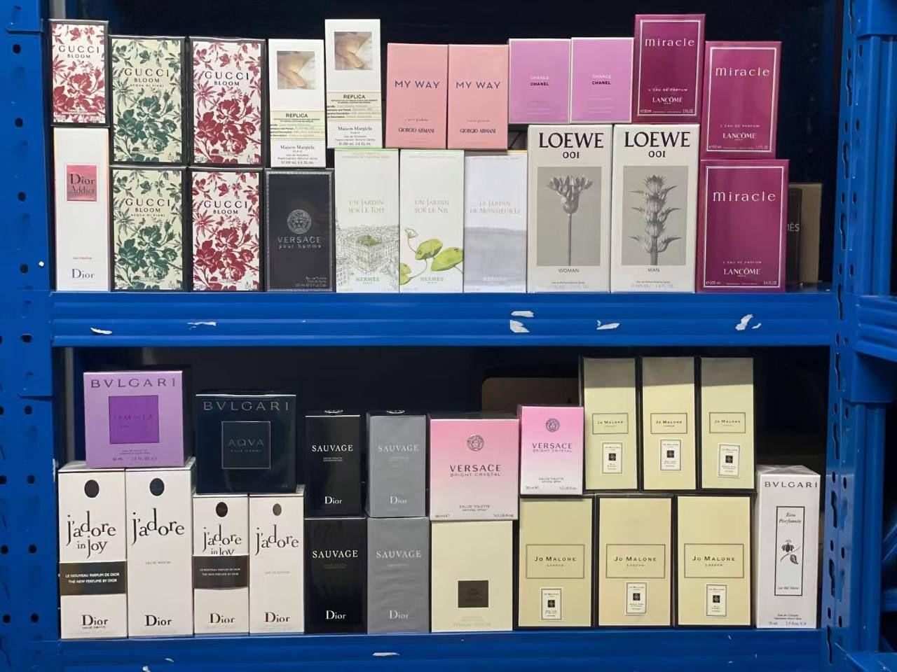 Shelf displaying various perfume boxes in different colors and brands.